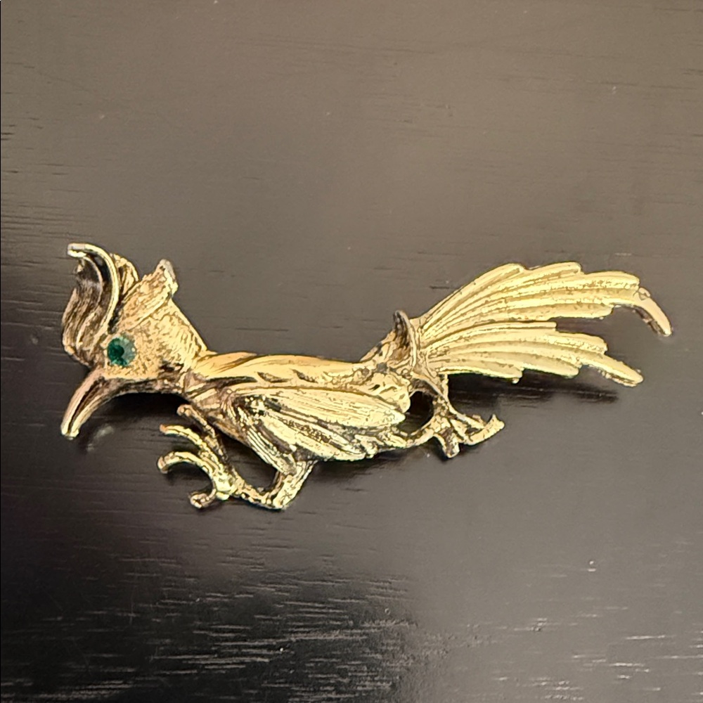 gold-tone roadrunner bird brooch pin with a green rhinestone eye